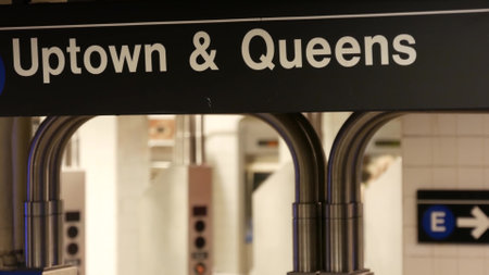 New York subway station interior. Text sign: Uptown, Queens. Manhattan underground metropolitan....