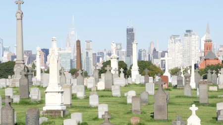 New York City, United States - 14 Sept 2023: Calvary cemetery in Queens, USA. Manhattan Midtown urban skyline cityscape architecture. Tombstones on graves, huge graveyard. Large cemetry grass lawn.のeditorial素材