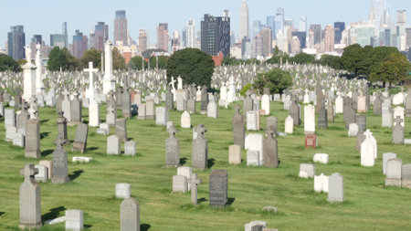 New York City, United States - 14 Sept 2023: Calvary cemetery in Queens, USA. Manhattan Midtown urban skyline cityscape architecture. Tombstones on graves, huge graveyard. Large cemetry grass lawn.のeditorial素材