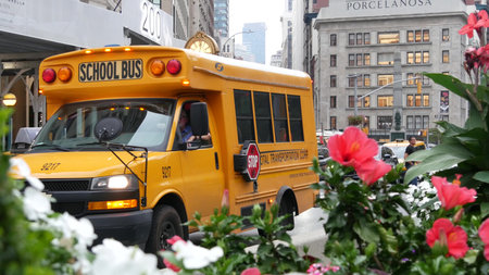 New York City, United States - 8 Sept 2023: Yellow School Bus on Manhattan street, Fifth 5 avenue. Children education. USA transportation, american shuttle. Worth Square and Madison Sq, Broadway Clockのeditorial素材