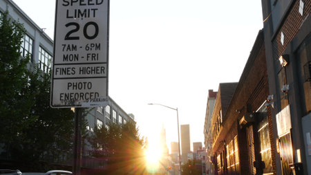 New York City, United States - 1 Sept 2023: Street crossroad, speed limit traffic sign, transport road signage, Queens, Long Island. Manhattan cityscape. Sunset, golden hour sunshine rays.のeditorial素材