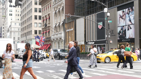 New York City, United States - 11 Sept 2023: Manhattan Midtown street, Fifth 5 avenue. American urban road car traffic, crossroad intersection. Yellow taxi in USA. People pedestrians. Shopping stores.のeditorial素材