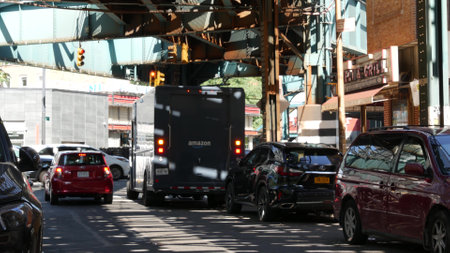 New York City, United States - 31 Aug 2023 Elevated subway above street. Metropolitan bridge over road, Queens. Long Island metro line, Court Square. Amazon and FedEx truck under railway track. Diner.のeditorial素材