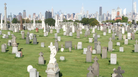 New York City, United States - 14 Sept 2023: Calvary cemetery in Queens, USA. Manhattan Midtown urban skyline cityscape architecture. Tombstones on graves, huge graveyard. Large cemetry grass lawn.のeditorial素材