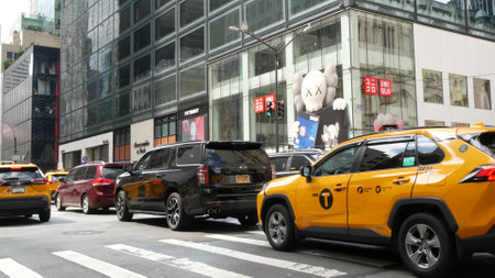 New York City, United States - 11 Sept 2023: Manhattan Midtown street, Fifth 5 avenue. American urban road car traffic, crossroad intersection. Yellow taxi in USA. People pedestrians. Shopping stores.のeditorial素材