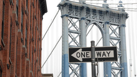Manhattan bridge in Brooklyn Dumbo, New York City, United States of America. Red brick building architecture, windows on Washington street. Tourist landmark in NYC, USA. One way road sign.の写真素材
