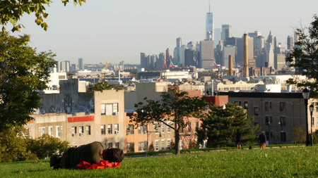 New York City, United States - 3 Sept 2024: Manhattan downtown financial district skyline, Brooklyn Sunset Park. Cityscape with skyscraper building, World Trade Center. Homeless man sleeping on groundのeditorial素材