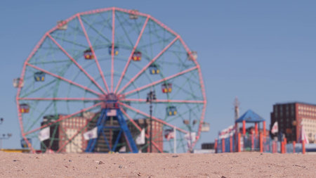 Coney Island sandy beach in Brooklyn, New York, United States. Boardwalk near retro luna park. Ferris wheel in american amusement park on ocean coast. Waterfront summer holiday promenade in NYC, USA.の写真素材