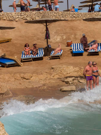 Sharm el-Sheikh, Egypt - February 25, 2013: tourists on the beach in Sharm el-Sheikh under the umbrella watching the reef and the beautiful waters of the Red Sea.のeditorial素材