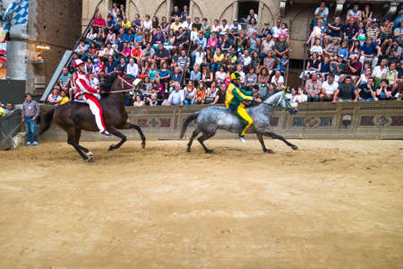 Siena, Italy - June 29, 2014: horses run on the straight under the stands of the spectators in Palio of Siena in tuscan, Italy. Medieval horse races the Palio of Siena in Tuscan Italy.のeditorial素材