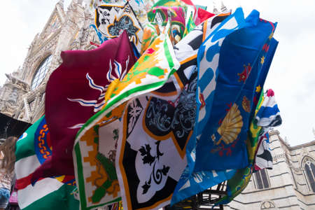 Flags of the "contrada" of palio Siena, waving in front of the cathedralのeditorial素材
