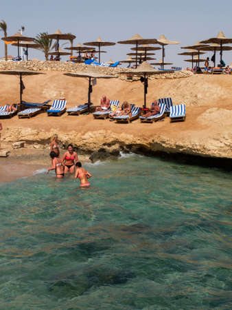 Sharm ElSheikh Egypt March 02 2013: tourists on the beach in Sharm ElSheikh under the umbrella watching the reef and the beautiful waters of the Red Sea.のeditorial素材