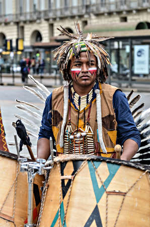 Turin Italy  April 27 2013: Red indian in traditional costume plays in the center of Turin Italy. Street performance of a group of Native Americans with sounds and traditional dancing.のeditorial素材