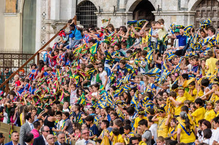 Siena Italy  July 29 2014: Boys rejoice and sing a chorus of encouragement during the Palio of Siena. Tribune of the spectators in Palio of Siena in tuscany Italy. Medieval horse races the Palio of Siena in Tuscan Itaのeditorial素材