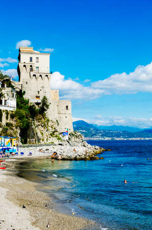 Cetara Italy  October 2 2013: Cetara small beach village on the Amalfi Coast LA beach is defended by an ancient Saracen tower. Bathers on the beach on a warm October day. In the background you can see the city of Salernoのeditorial素材