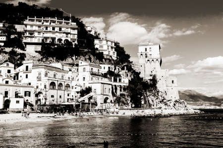 Cetara Italy  October 2 2013: Cetara small beach village on the Amalfi Coast LA beach is defended by an ancient Saracen tower. Bathers on the beach on a warm October day. In the background you can see the city of Salernoのeditorial素材