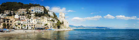 Cetara Italy  October 2 2013: Cetara small beach village on the Amalfi Coast LA beach is defended by an ancient Saracen tower. Bathers on the beach on a warm October day. In the background you can see the city of Salernoのeditorial素材