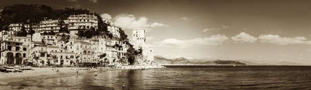 Cetara Italy  October 2 2013: Cetara small beach village on the Amalfi Coast LA beach is defended by an ancient Saracen tower. Bathers on the beach on a warm October day. In the background you can see the city of Salernoのeditorial素材