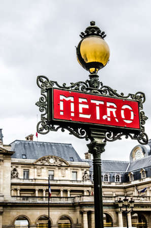 traditional Paris red metro sign against the backdrop of the buildingのeditorial素材