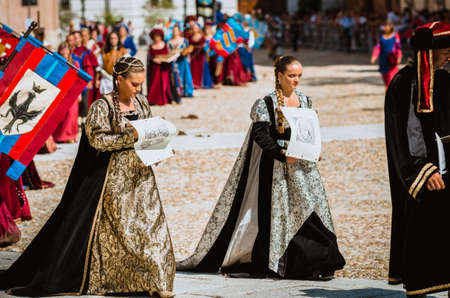 Asti, Italy - September 16, 2012: Procession of street performers in medieval costumes parading in the Palio of Asti. A pair of noble fashion in the Middle Agesのeditorial素材