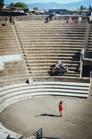 Pompeii, Italy - October 3, 2013: beautiful tourist pretends a recitation in the ancient Roman...