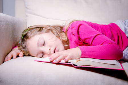 little girl asleep on the bookの写真素材