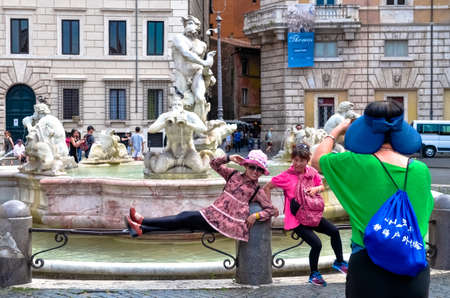 Rome, Italy - June 30, 2016: Asian tourists posing for photograph with fountain of Moro in Piazza Navona in Romeのeditorial素材