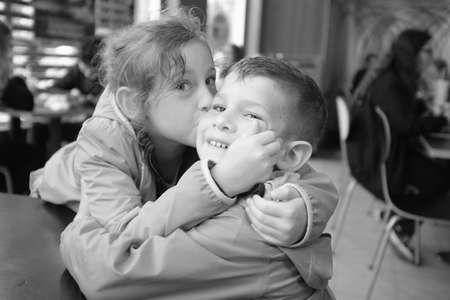 Black an white of Sister kiss on the cheek brother