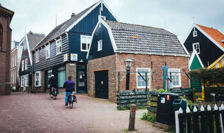 Volendam , Netherlands 19 June 2016: Residents of the village of Volendam by bike between the typical house of a Dutch fishing village, the Netherlandsのeditorial素材