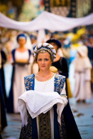 Asti, Italy - September 19, 2010: Young Medieval Princess, during the historic parade of the Palio of Asti in Piedmont, Italy. Young damadel Middle Ages at the Palio with flowersのeditorial素材