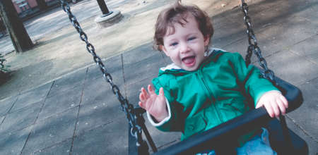 little girl in the park with playgroundの写真素材