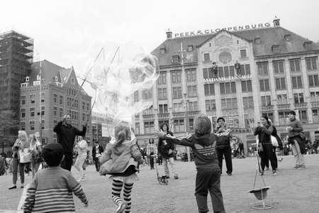 Amsterdam, Netherlands - June 16, 2016: Street artist making soap bubbles on the street in Dam Square in Amsterdam in black and white, Netherlands.のeditorial素材