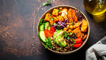 Top view of a nutritious plant based meal with avocado, chickpeas, sweet potato, and fresh greens on a dark background. Healthy eating concept.の素材