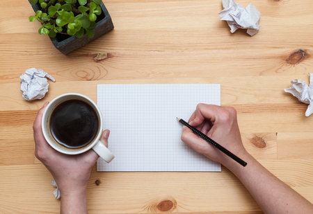 Blank notepad with pencil and coffee on wooden deskの写真素材