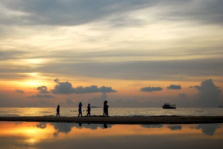 people enjoying the sunset on the beach の写真素材