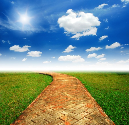 Alone way green grass cloudy blue sky to destination and green way to the futureの写真素材