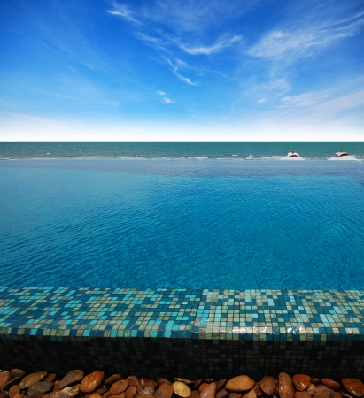 Swimming pool near the beach at high class resort in thailand for relax relaxation beautiful sea sand sun blue sky in Thailandの写真素材