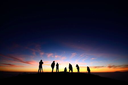 Silhouette of Hiker and Photographer with colorful sunrise