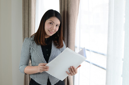 young attractive woman with briefcase and checking documentの写真素材