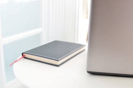 Note book on the table with laptop computer