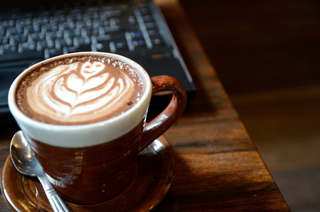 Laptop, notebook and coffee cup on wood deskの写真素材