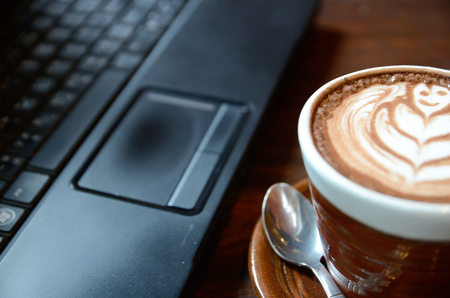 Laptop, notebook and coffee cup on wood deskの写真素材