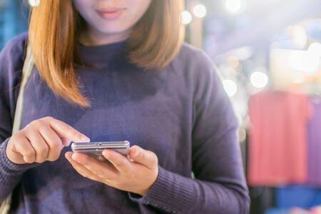 Woman touching smartphone with circle bokeh light at night live  shopping mallの写真素材