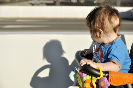 Baby in buggy look on shadowの写真素材