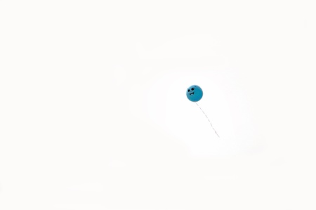 Blue balloon with smile in skyの写真素材