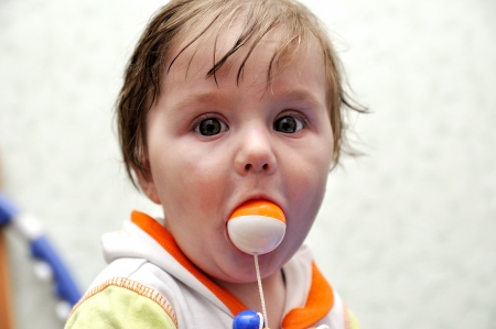 Portrait baby boy with toy ball in mouth