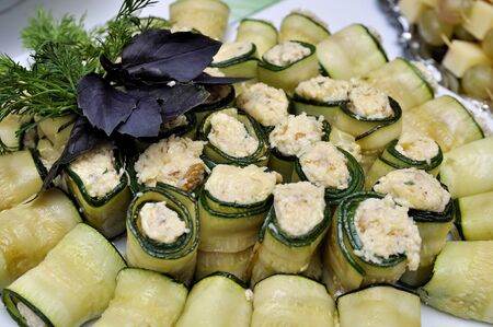 Snack with food rolled in cucumber served with dill and basilの写真素材