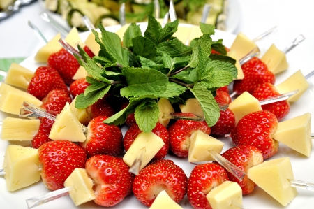 Canape with strawberry and cheese served with mint leafの写真素材