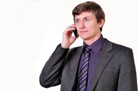 Young businessman in violet tie speaks by phoneの写真素材