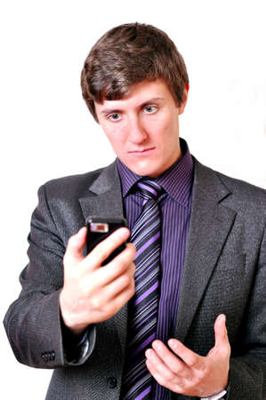 Businessman evil looks at the mobile phoneの写真素材